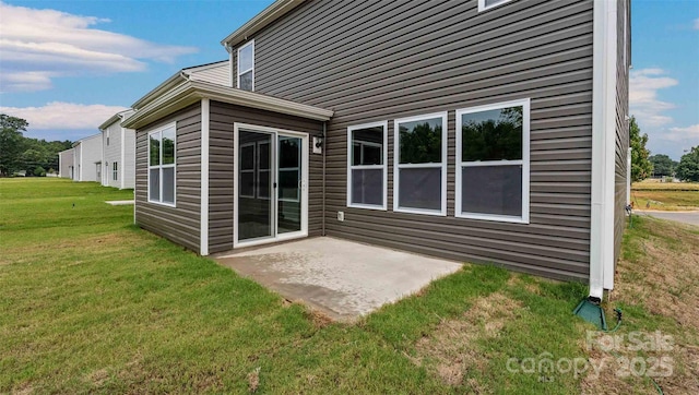 rear view of property with a patio and a lawn