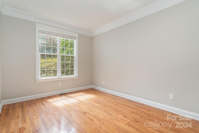 spare room with light hardwood / wood-style flooring and crown molding