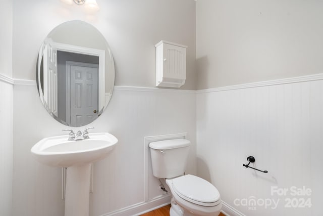 bathroom with hardwood / wood-style flooring and toilet