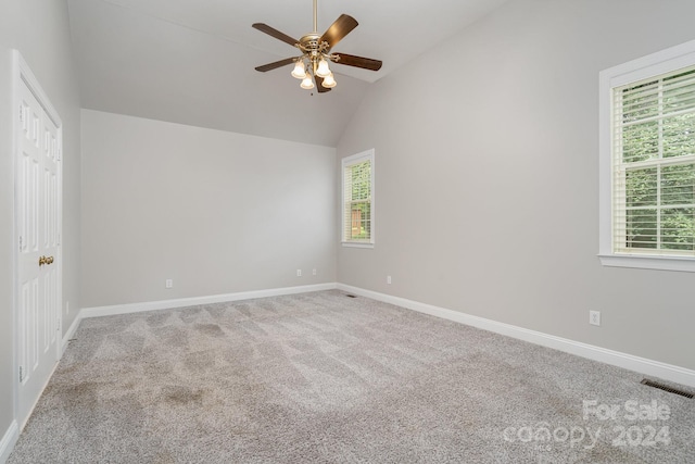 carpeted empty room with ceiling fan and lofted ceiling