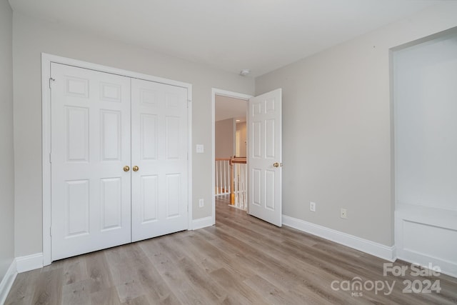 unfurnished bedroom featuring light hardwood / wood-style flooring and a closet