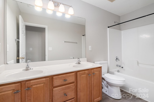 full bathroom with  shower combination, hardwood / wood-style flooring, vanity, and toilet