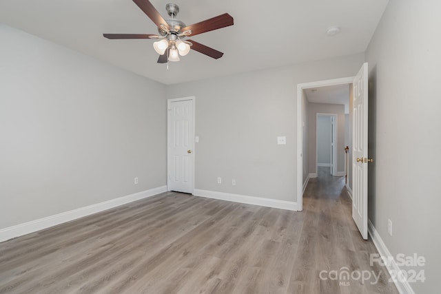 unfurnished bedroom with ceiling fan and light wood-type flooring