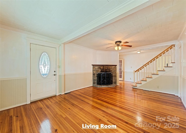 foyer with crown molding, stairs, a fireplace, and hardwood / wood-style floors