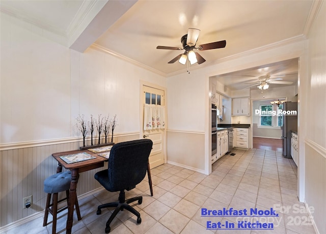 home office featuring light tile patterned floors, ceiling fan, crown molding, and wainscoting