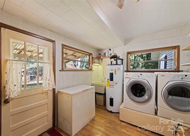 laundry room with a wealth of natural light, washing machine and dryer, laundry area, and water heater