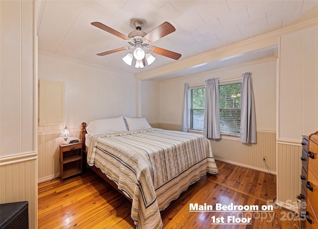 bedroom featuring ornamental molding, hardwood / wood-style floors, and a ceiling fan