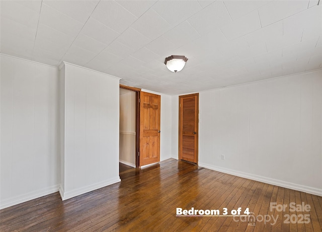 interior space featuring wood-type flooring and baseboards