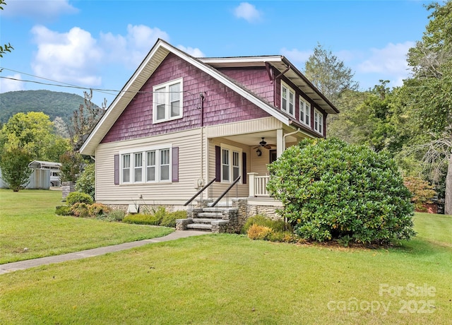 view of front of house featuring a ceiling fan, a front yard, and a porch