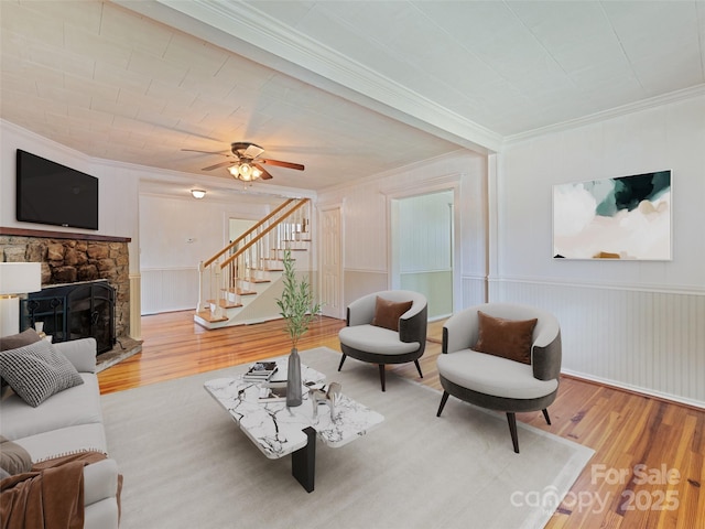 77 Twinbrook Ln, Maggie Valley, NC 28751 - living area with ornamental molding, wood finished floors, stairs, a fireplace, and a ceiling fan