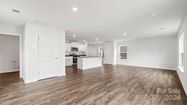 unfurnished living room with sink and hardwood / wood-style floors