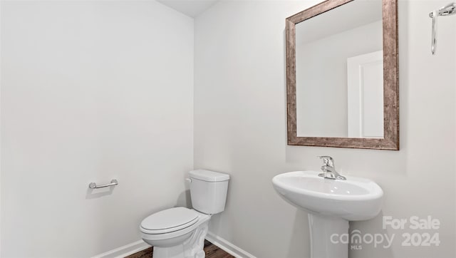 bathroom with hardwood / wood-style floors and toilet