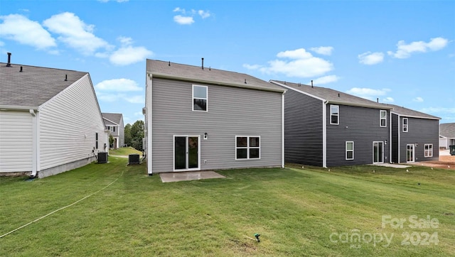 rear view of house featuring central AC unit, a patio area, and a yard