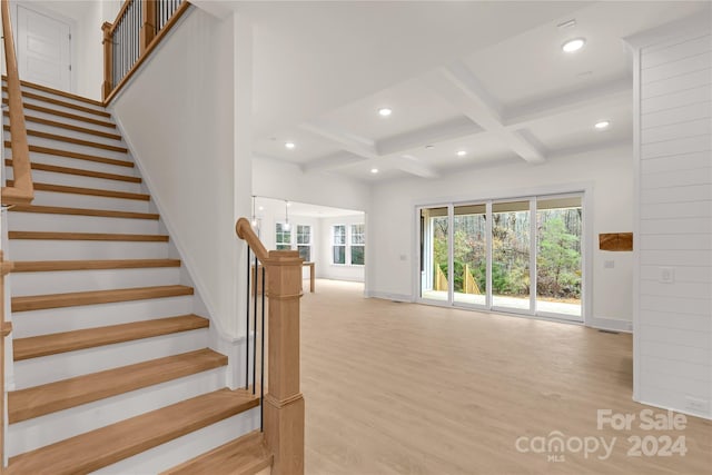 stairway with beamed ceiling, hardwood / wood-style flooring, and coffered ceiling