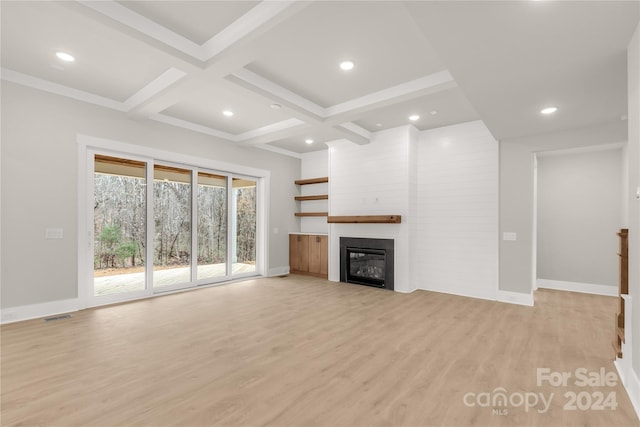 unfurnished living room with a fireplace, beamed ceiling, coffered ceiling, and light wood-type flooring