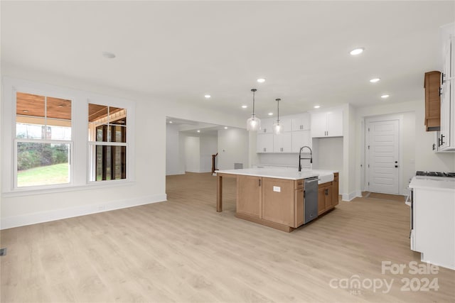 kitchen featuring white cabinets, decorative light fixtures, light hardwood / wood-style flooring, and an island with sink