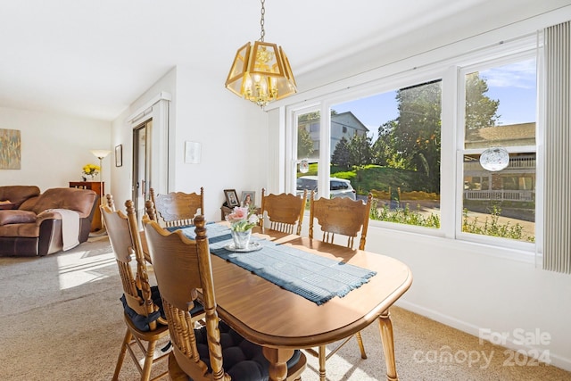 carpeted dining space featuring a notable chandelier