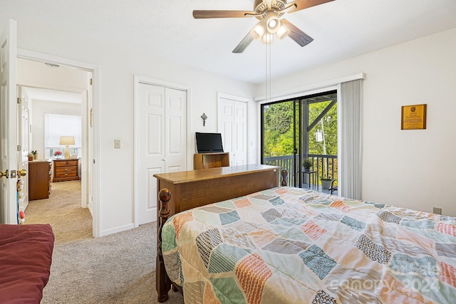 bedroom with access to exterior, ceiling fan, two closets, and light colored carpet