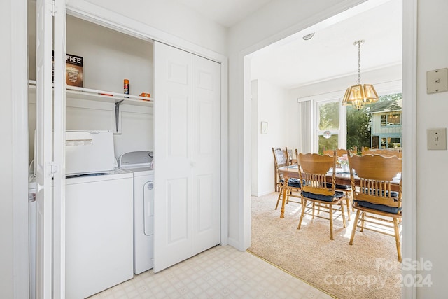 laundry area featuring a notable chandelier and washer and dryer