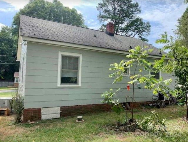 view of side of home with a yard