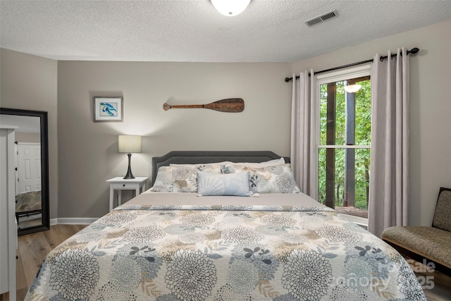 bedroom featuring hardwood / wood-style flooring and a textured ceiling