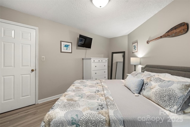 bedroom featuring a textured ceiling and light wood-type flooring