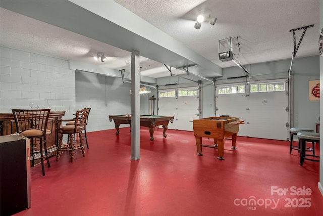 recreation room with pool table, concrete flooring, and a textured ceiling