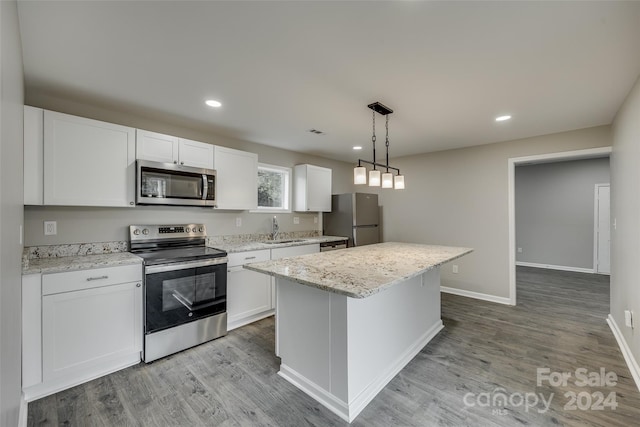 kitchen featuring light hardwood / wood-style flooring, a kitchen island, stainless steel appliances, and white cabinetry