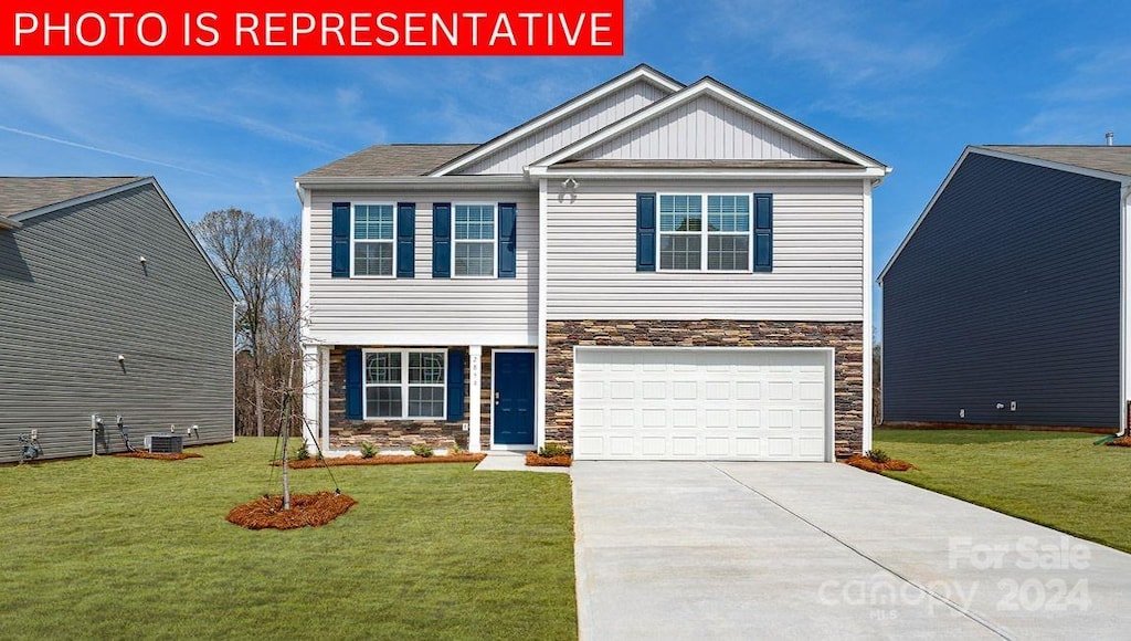 view of front of home with a garage, central AC, and a front yard