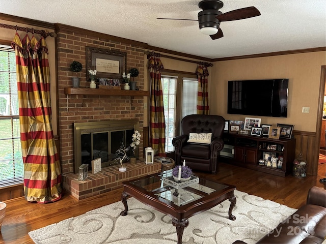 living room with a textured ceiling, hardwood / wood-style flooring, a fireplace, and a wealth of natural light