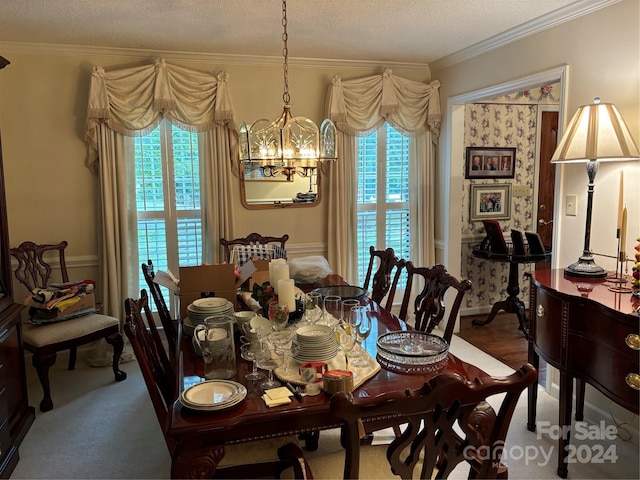 dining room with a healthy amount of sunlight, ornamental molding, a textured ceiling, and an inviting chandelier