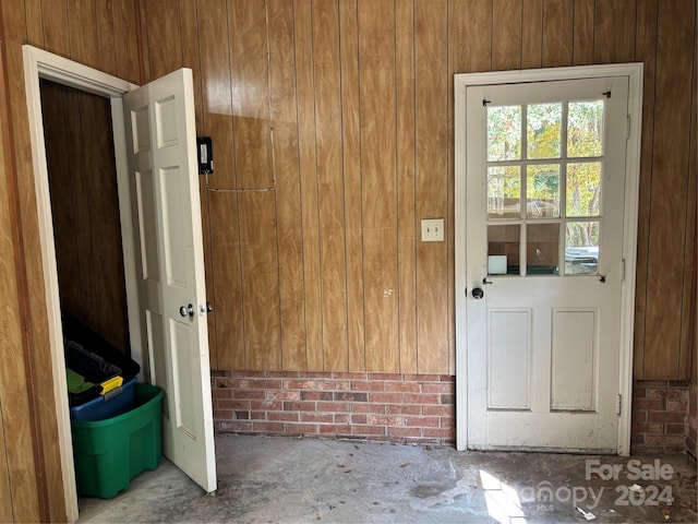 entryway with wood walls