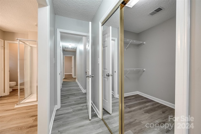 walk in closet with wood-type flooring