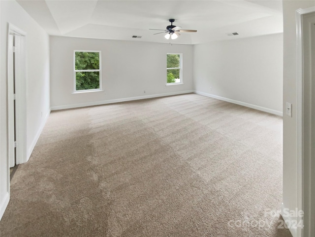 unfurnished room with ceiling fan, light colored carpet, and plenty of natural light