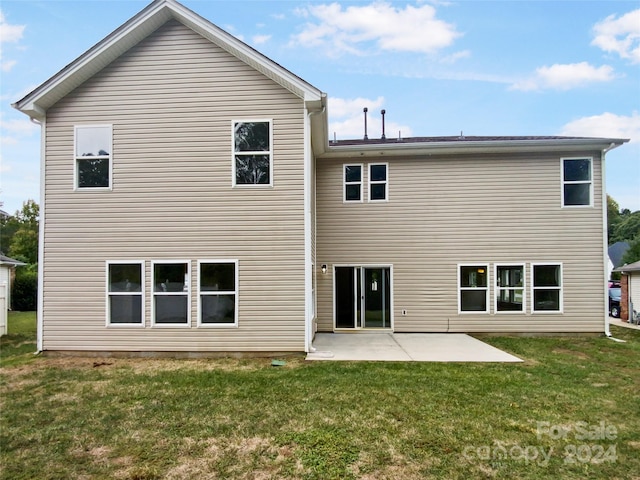 back of house featuring a lawn and a patio area