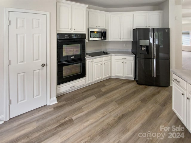 kitchen with white cabinetry, dark hardwood / wood-style flooring, and black appliances