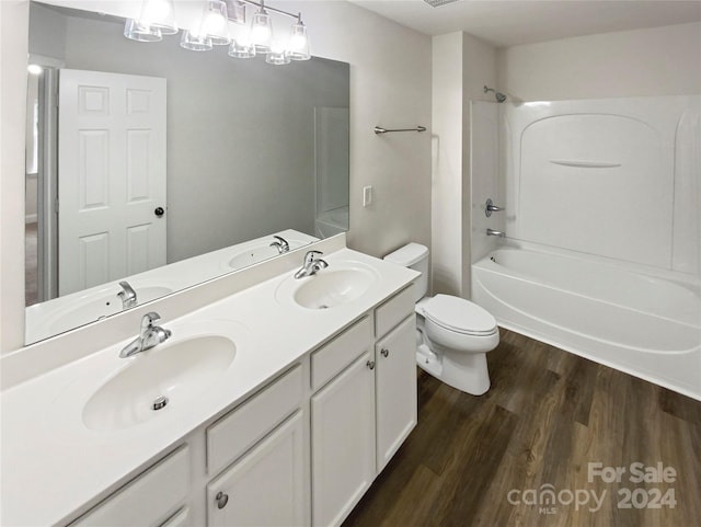 full bathroom featuring vanity, wood-type flooring, washtub / shower combination, and toilet