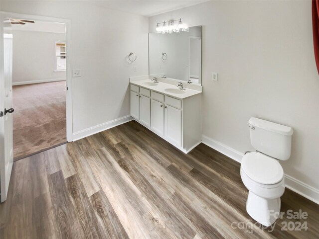 bathroom featuring ceiling fan, vanity, toilet, and hardwood / wood-style flooring