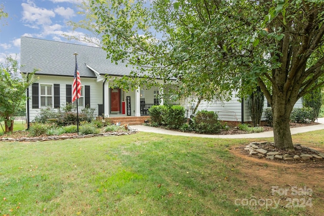 view of property hidden behind natural elements featuring a front yard