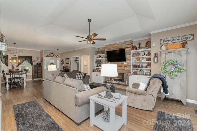 living room featuring light hardwood / wood-style flooring, a tray ceiling, ceiling fan, and crown molding