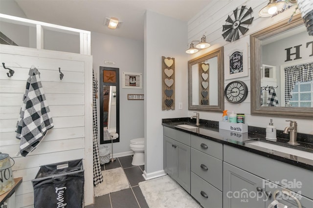 bathroom with a shower with curtain, vanity, toilet, and tile patterned floors