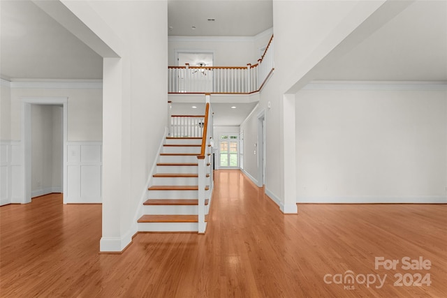 staircase featuring ornamental molding and hardwood / wood-style flooring