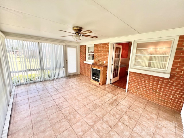 unfurnished sunroom featuring ceiling fan