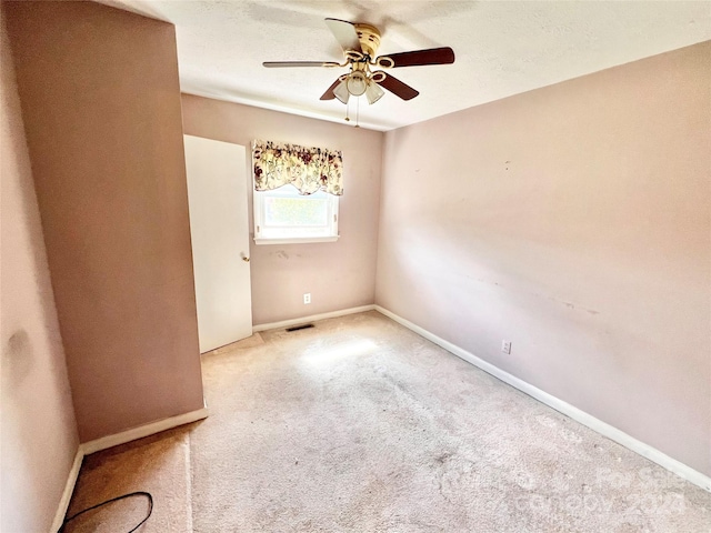 carpeted empty room featuring ceiling fan