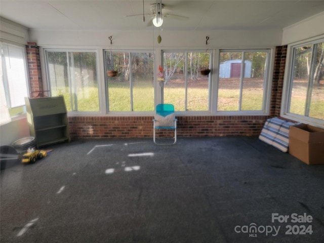 unfurnished sunroom featuring ceiling fan