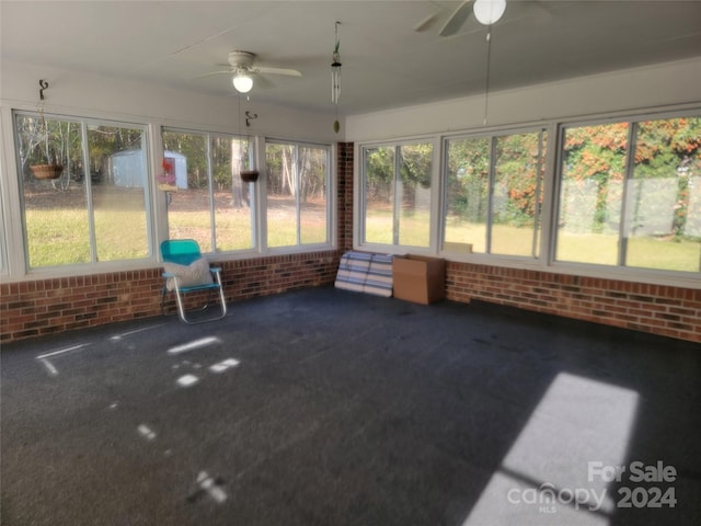 unfurnished sunroom with ceiling fan