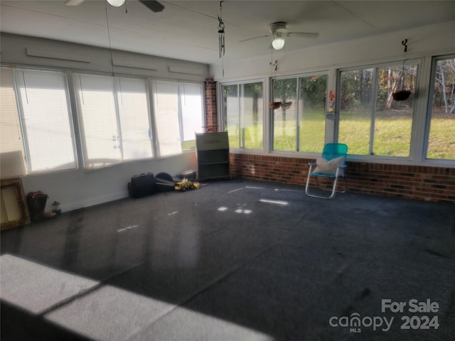 sunroom featuring ceiling fan and plenty of natural light