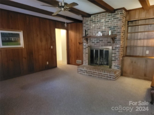 unfurnished living room with beam ceiling and wood walls