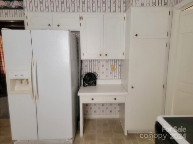 kitchen with white cabinetry and white refrigerator with ice dispenser