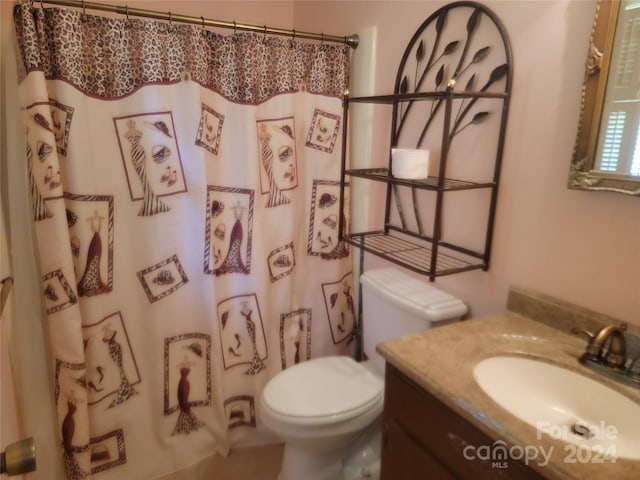 bathroom featuring vanity, toilet, and walk in shower